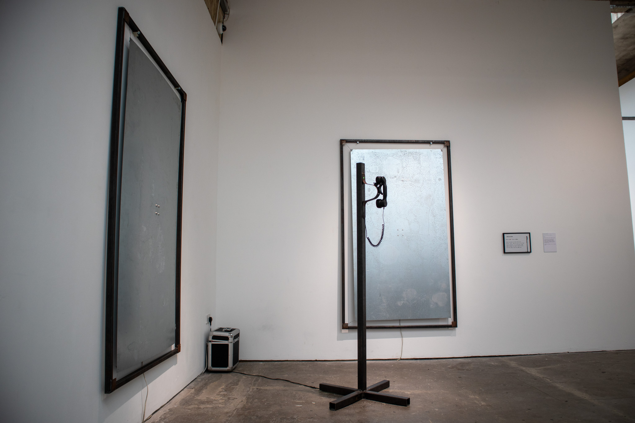 Phone on a metal pole with a red light ontop of it